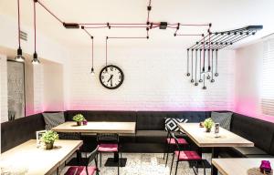 a restaurant with tables and a clock on the wall at Dom Retro Pivnica in Jastrzębie Zdrój