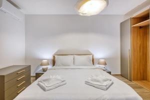 a bedroom with a bed with two towels on it at Seafront 3 Bedroom Luxury Getaway in St. Paul's Bay