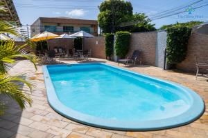 a large blue swimming pool in a yard at Vila Olaria Hotel in Penha