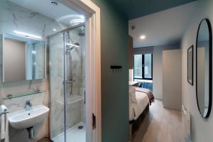 a bathroom with a sink and a shower and a bed at Queen Street Place in Galway