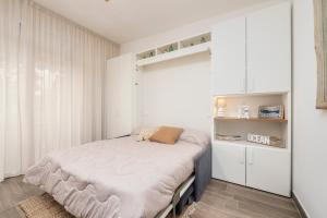 a bedroom with a bed in a white room at 070 - Villa OLANDA con veranda VISTA MARE a 5 minuti SPIAGGIA con PISCINA CONDOMINIALE in Sestri Levante