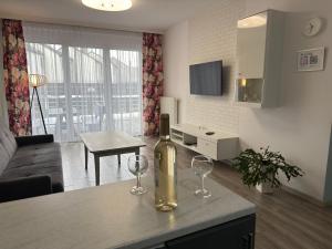 a bottle of wine sitting on a kitchen counter with two wine glasses at 1 Tyskie Apartamenty z prywatnym ogródkiem in Tychy