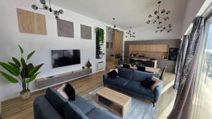 a living room with two blue couches and a table at Forest Edge Lake House in Desmerice