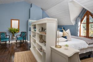 a bedroom with blue walls and a bed and a window at Caledon Grace Guesthouse in Caledon