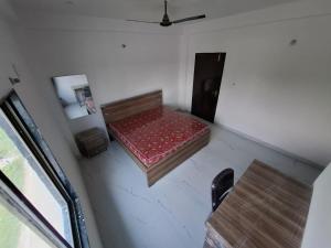 a small room with a bed and a table at VnM Paradise in Chunār