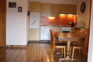 a kitchen with a table and chairs and a refrigerator at Anzère appartement de vacances calme et sympa in Anzère +6 photos