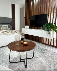 a living room with a coffee table and a tv at Makupula Apartments in Lusaka