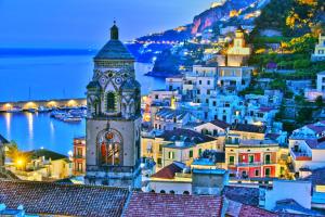 a view of a town with a clock tower at night at Giacarda Suite in Salerno