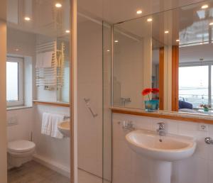 a bathroom with a sink and a shower and a toilet at Hanseat in Helgoland +48 photos