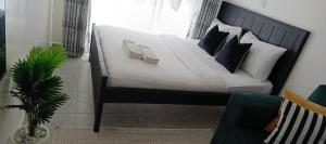 a bedroom with a bed with white sheets and pillows at Home Away in Ongata Rongai 