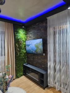 a living room with a tv on a brick wall at POSEJDON DELUXe 4 in Vrnjačka Banja