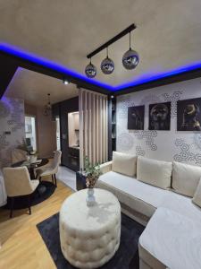a living room with a white couch and a table at POSEJDON DELUXe 4 in Vrnjačka Banja