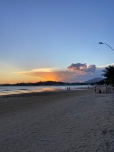 a group of people on a beach at sunset at Cantinho Sol e Sal in Guarapari