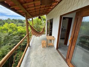 a balcony of a house with a hammock on it at CASA NANDOS Flat Essência !!! in Itacaré