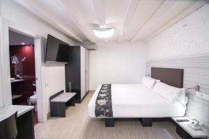 a hotel room with a bed and a bathroom at Petit Palace Boqueria Garden in Barcelona