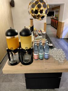 a table with two coffee makers and bottles of water at DER Hirsch Hotel in Monschau