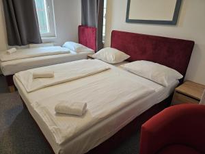 two beds in a hotel room with towels on them at Hotel Astral Vienna in Vienna