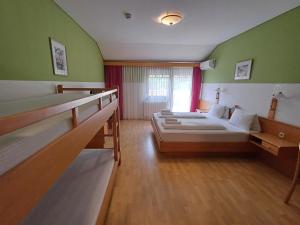zwei Betten in einem Zimmer mit grünen Wänden in der Unterkunft Georgshof in Podersdorf am See