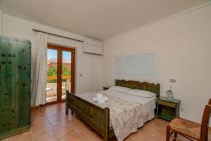 a bedroom with a bed and a large window at Club Esse Residence Capo D'orso in Palau +31 photos