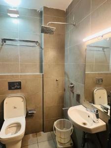 a bathroom with a toilet and a sink at Hotel Enigma in Indore +23 photos