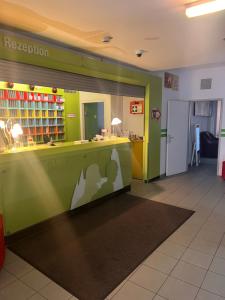 a library with green and yellow walls and a reception counter at Hotel Astral Vienna in Vienna +8 photos