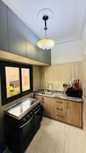 a large kitchen with a sink and a stove at SLAR Résidence in Douala