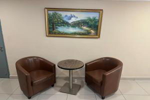 two chairs and a table and a picture on the wall at Poorna Hotel at Jalan Ipoh Sentul Kuala Lumpur in Kuala Lumpur +26 photos