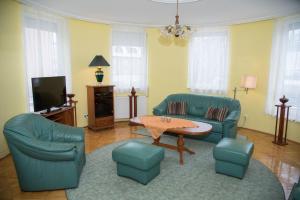 a living room with a couch and a table and chairs at Centrum Suite in Hévíz