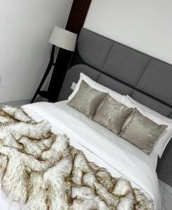 a bedroom with a white bed with a blanket and pillows at Makupula Apartments in Lusaka