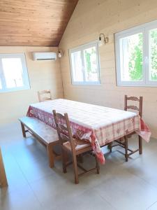 a large bed in a room with two chairs and two windows at Le Chalet des Pas Sages in Longevilles-Mont-dʼOr