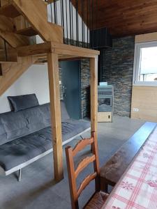 a living room with a bunk bed and a chair at Le Chalet des Pas Sages in Longevilles-Mont-dʼOr
