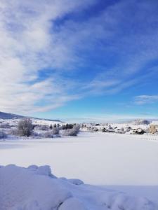 a field covered in snow with a blue sky and clouds at Le Chalet des Pas Sages in Longevilles-Mont-dʼOr