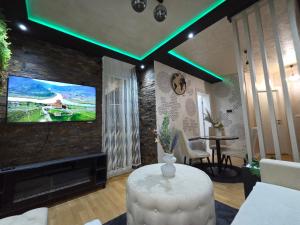 a living room with a tv on a brick wall at POSEJDON DELUXe 4 in Vrnjačka Banja +21 photos