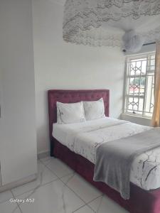 a bedroom with a bed and a window at Blantyre Airport Lodge in Chileka