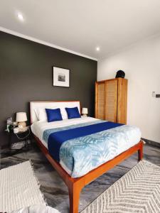 a bedroom with a large bed with blue pillows at Santo Guesthouse in Canggu