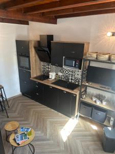 a kitchen with black cabinets and a table at Triplex Hyper Centre Bastia Direct Musée et Citadelle in Bastia