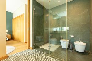 a bathroom with a glass shower and a toilet at Villa Mar in Troia +55 photos