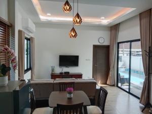 a living room with a couch and a table at Niramit Pool Villa in Ban Chong Phli