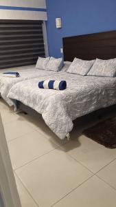 a bed with a blue and white pillow on it at Condominio Xaman Ha 7107 in Playa del Carmen +10 photos