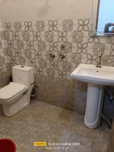 a bathroom with a toilet and a sink at Radha Rani homestay in Vrindāvan +6 photos