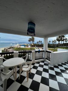 a porch with a table and chairs and the ocean at CHY dreams in Cabo Negro