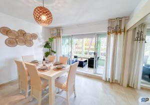 a dining room with a white table and chairs at Apartamento Deluxe Sotogrande in San Roque