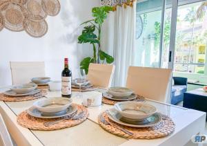 a table with bowls and plates and a bottle of wine at Apartamento Deluxe Sotogrande in San Roque +19 photos