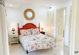 a bedroom with a bed and a mirror on the wall at Apartamento Deluxe Sotogrande in San Roque