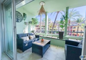 a living room with two blue chairs and a table at Apartamento Deluxe Sotogrande in San Roque