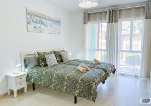 a bedroom with a bed and a large window at Apartamento Deluxe Sotogrande in San Roque