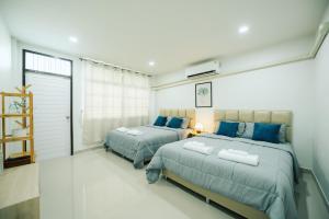 a bedroom with two beds and a window at 11 House - 9 mins drive to LeeGarden,parking available in Ban Kohong