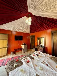 a bedroom with two large beds with red walls at Rum Oasis Luxury Camp in Wadi Rum