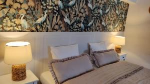 a bedroom with a bed with two lamps and a painting at Las i Woda in Lubin