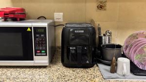 a coffee maker sitting next to a microwave on a counter at Spacious 2BR Apartment,3 Bathrooms, Near Mall in Abu Dhabi
